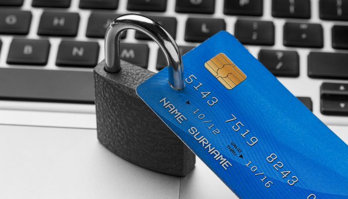 alto-angulo-de-bloqueio-com-cartao-de-credito-em-cima-laptop