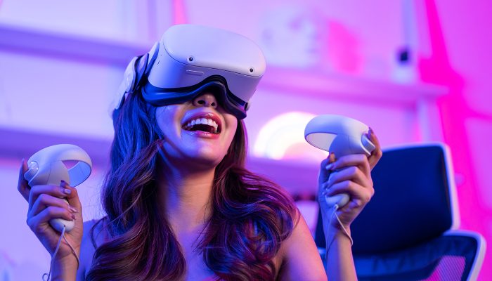 Asian young Esport woman gamer use technology VR glasses and play game. Attractive beautiful female gaming player wear virtual reality headset, feel excited and enjoy broadcast live stream online game
