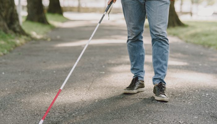 Blind man. People with disability, handicapped person and everyday life. Visually impaired man with walking stick, descending steps in city park.