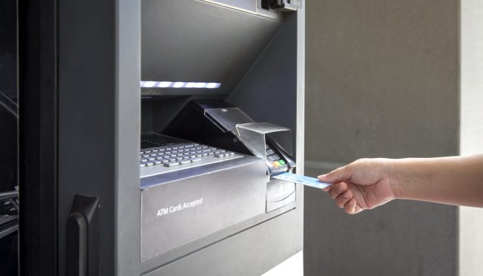 Close up female hand Using Credit Card bank of ATM machine to withdraw money