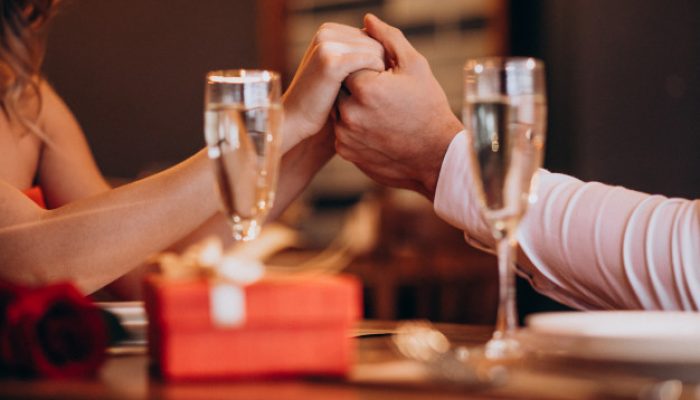 casal-de-maos-dadas-na-noite-de-dia-dos-namorados-em-um-restaurante_1303-20351