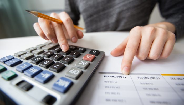 closeup-accountant-hands-counting-calculator
