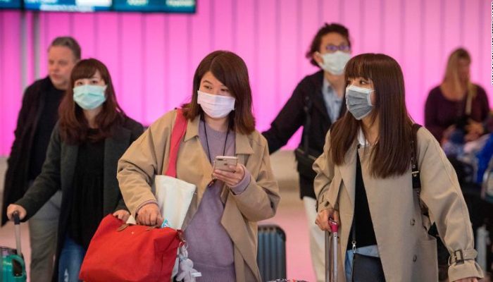 Passengers wear protective masks to protect against the spread of the Coronavirus as they arrive at the Los Angeles International Airport, California, on January 22, 2020. - A new virus that has killed nine people, infected hundreds and has already reached the US could mutate and spread, China warned on January 22, as authorities urged people to steer clear of Wuhan, the city at the heart of the outbreak. (Photo by Mark RALSTON / AFP) (Photo by MARK RALSTON/AFP via Getty Images)