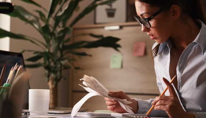 female-accountant-calculating-tax-bills-while-working-finances-office