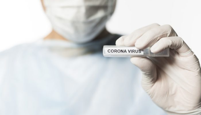 front-view-doctor-holding-tube-with-coronavirus_23-2148450252
