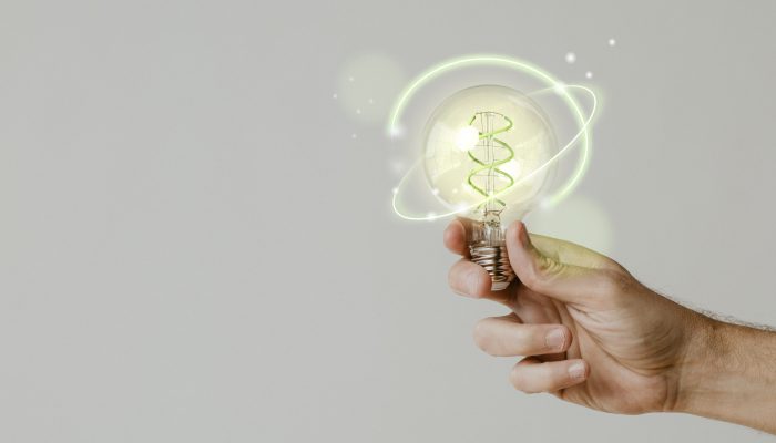 Green energy with hand holding an environmental light bulb background