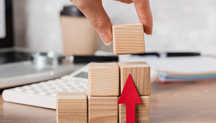 hand-placing-wooden-block-represent-growth