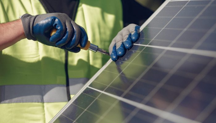 Engineer in a white helmet. Man near solar panel.