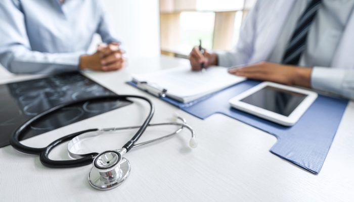 Professor Doctor consulting with patient discussing something and recommend treatment methods, Presenting results on report and x-ray film, Medicine and health care concept.