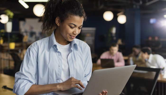 smiley-woman-holding-laptop-office-working