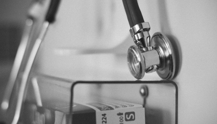 stethoscope-hanging-over-plastic-shelf-bw