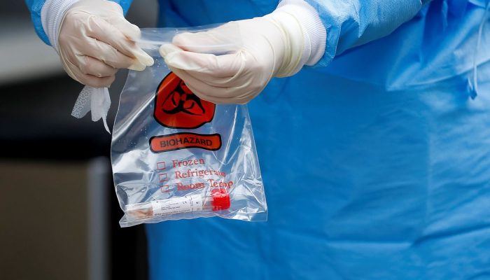 Um profissional de saúde realiza um teste finalizado em um local de testes de coronavírus fora dos Serviços Comunitários de Saúde Internacionais no Distrito Internacional de Chinatown durante o surto de doença por coronavírus (COVID-19) em Seattle, Washington, EUA, em 26 de março de 2020. REUTERS / Lindsey Wasson