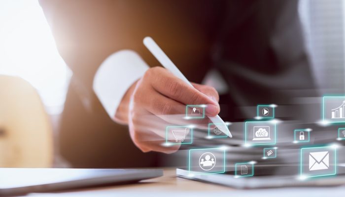 Concept technology internet and networking, businessman hand holding white pen with media icon on digital display.
