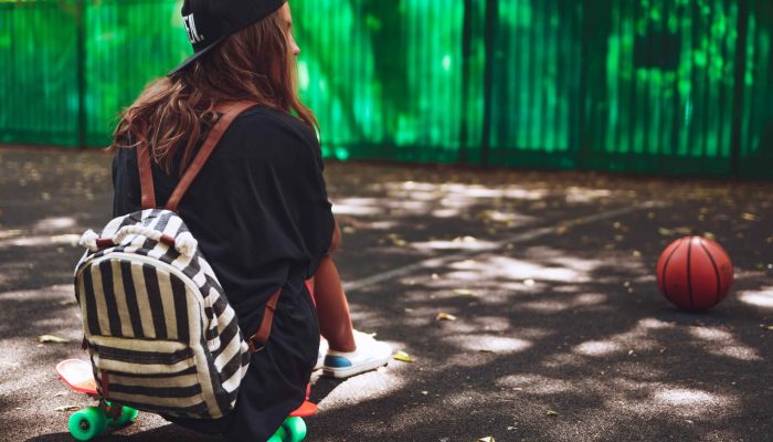 young-girl-sitting-plastic-orange-penny-shortboard-asphalt-cap